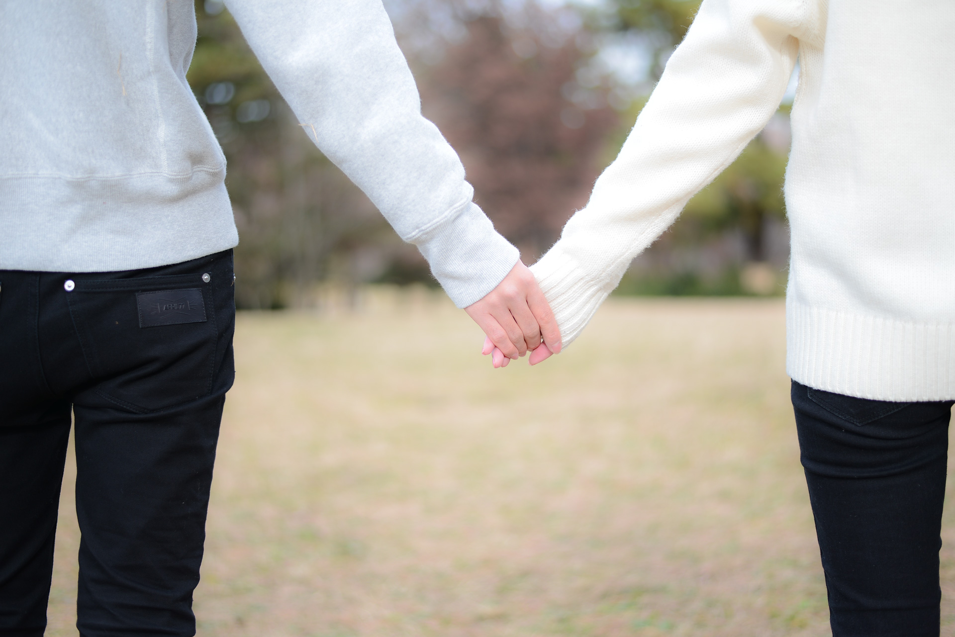 公園の散歩で手をつなぐカップル